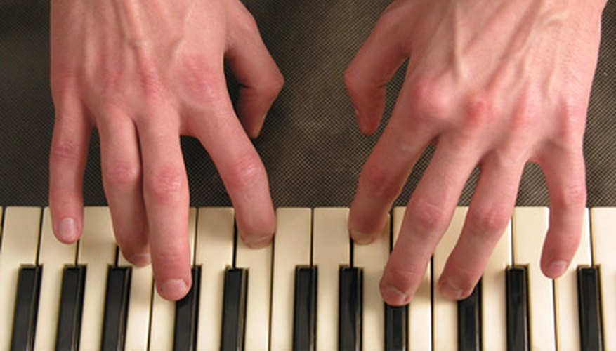 Photo Credit: hands on piano image by Pavel Losevsky from <a href='http://www.fotolia.com'>Fotolia.com</a> Reading a treble clef staff and a bass clef staff simultaneously takes practice.