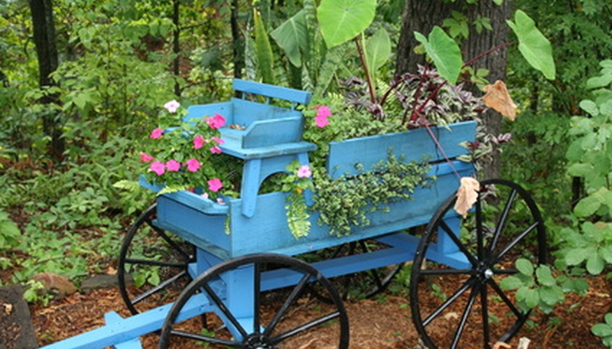 A little blue wagon that is being used for a gardening stand, showing the tongue, wheels, seat and box. A little blue wagon that is being used for a gardening stand, showing the tongue, wheels, seat and box.
