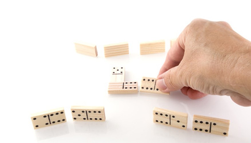 Standing domino tiles are easily knocked over if not secured in a stand. Standing domino tiles are easily knocked over if not secured in a stand.