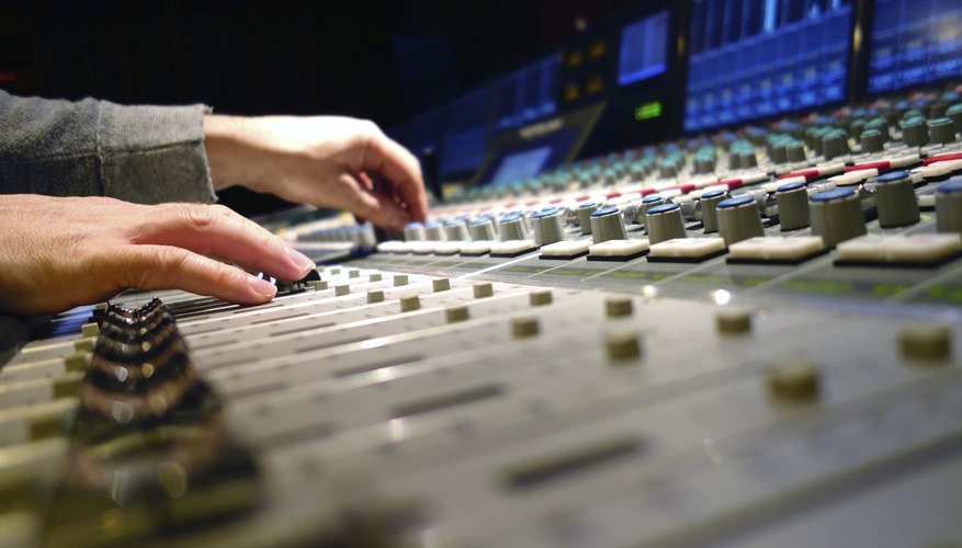 Hands adjusting mix board Hands adjusting mix board