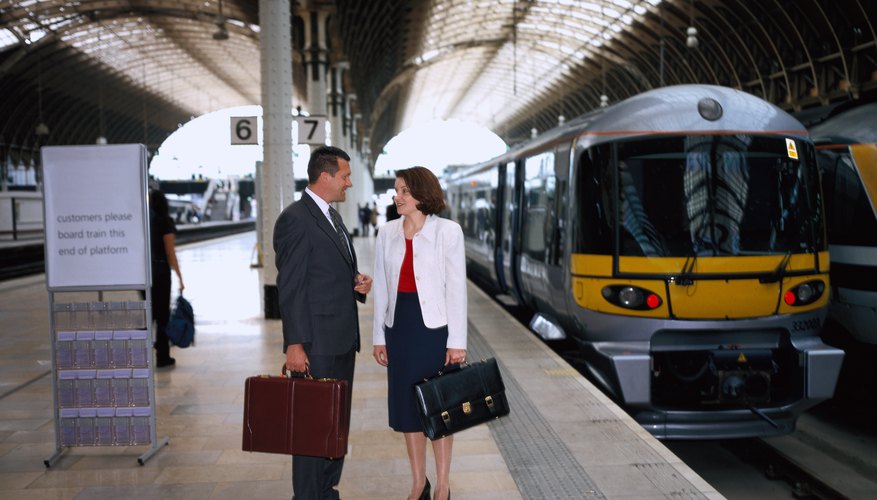 Business man and woman talking as a train arrives at the platform. Business man and woman talking as a train arrives at the platform.