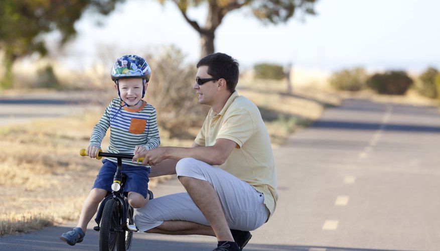 Boy with father learning to ride bicycle Boy with father learning to ride bicycle