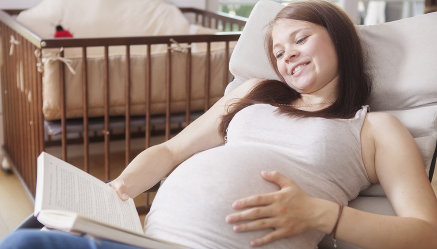 Pregnant woman reading a book out loud. Pregnant woman reading a book out loud.