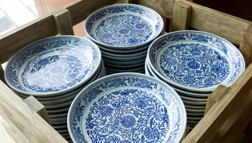 Photo Credit: Jeremy Wee/iStock/Getty Images China porcelain plates packed inside of a wooden crate.