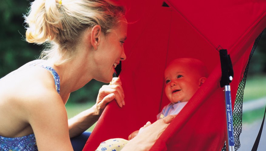 A mother smiling at her baby in a stroller. A mother smiling at her baby in a stroller.