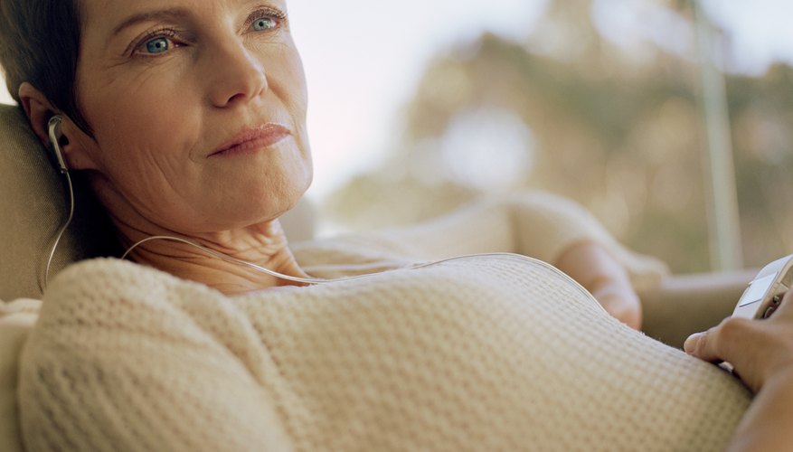 A woman is listening to music through her headphones. A woman is listening to music through her headphones.