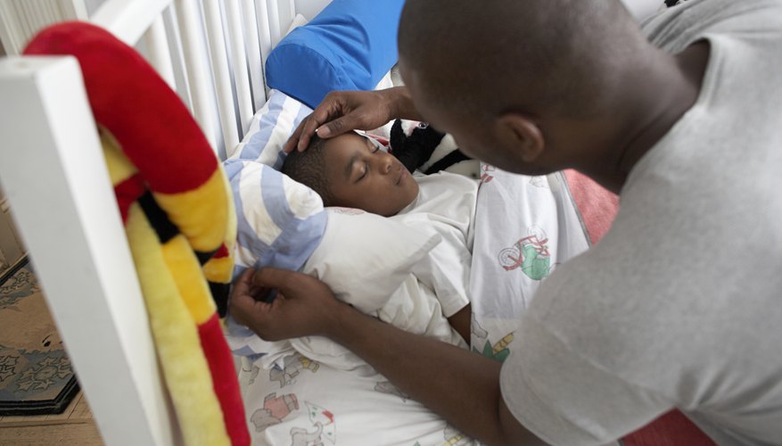 Caregiver tucking child in bed Caregiver tucking child in bed