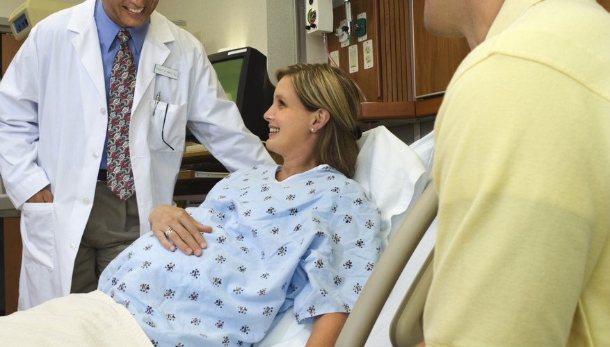 Pregnant woman in hospital talking to doctor Pregnant woman in hospital talking to doctor