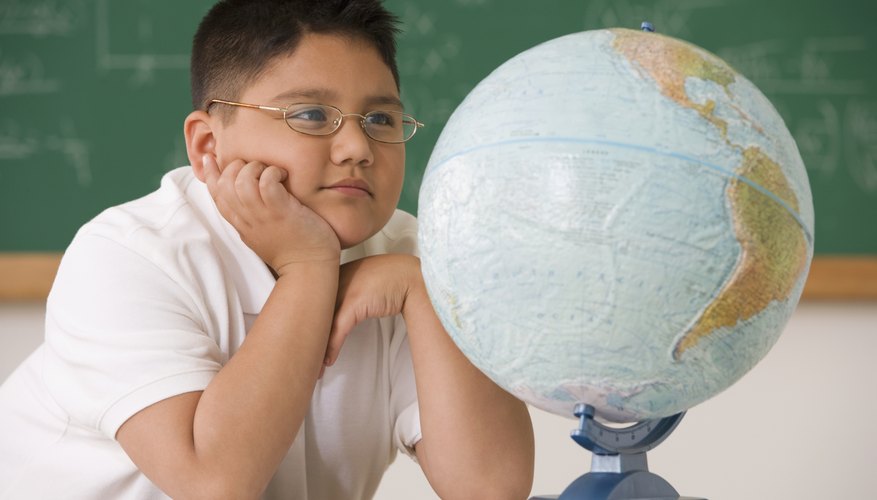 Young student looking at a globe. Young student looking at a globe.