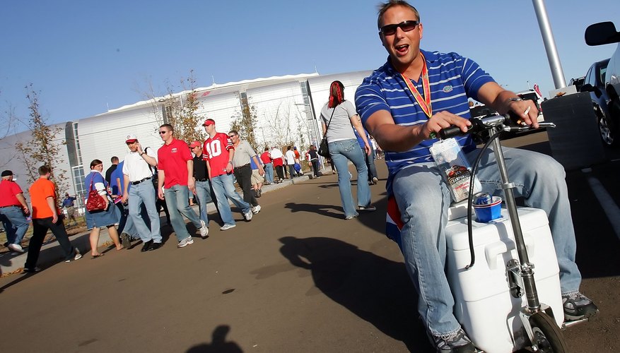 Photo Credit: Jed Jacobsohn/Getty Images Sport/Getty Images Football fan driving around parking lot with motorized cooler