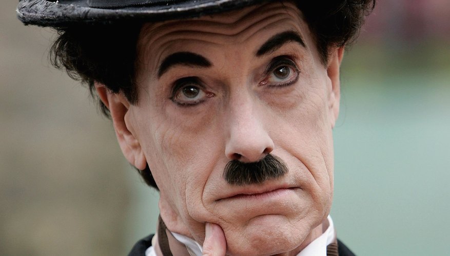 The actor impersonating Charlie Chaplin conveys thoughtfulness through pantomime. The actor impersonating Charlie Chaplin conveys thoughtfulness through pantomime.