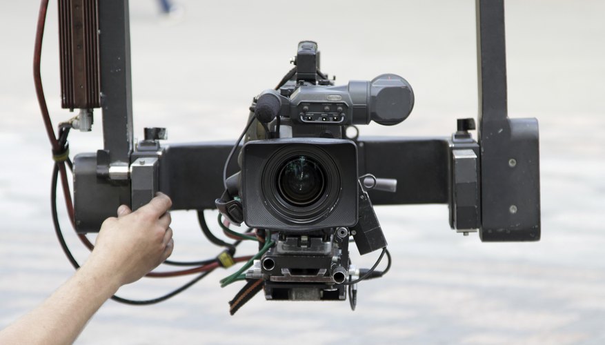 A close-up of a video camera mounted onto a crane to capture an outdoor shot. A close-up of a video camera mounted onto a crane to capture an outdoor shot.