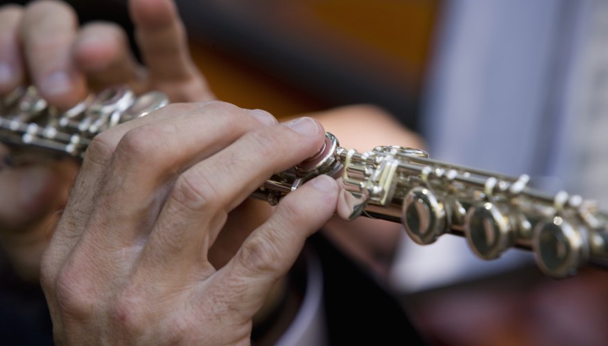 A close-up of a man holding a flute. A close-up of a man holding a flute.