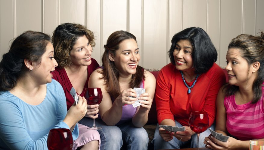 Photo Credit: Creatas/Creatas/Getty Images Friends playing a game and drinking wine