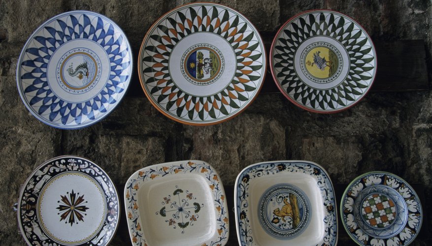 Traditional Italian plates displayed on a stone wall. Traditional Italian plates displayed on a stone wall.
