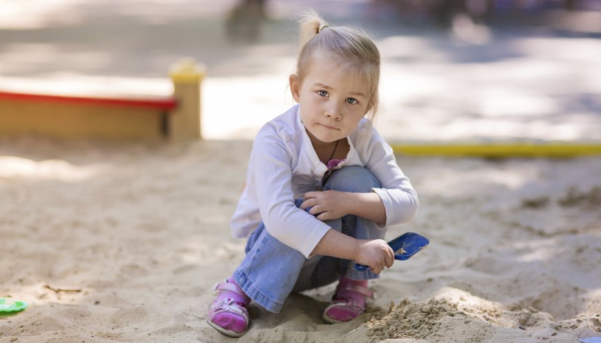 Young girl playing in sandbox. Young girl playing in sandbox.