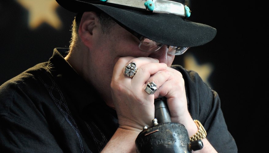 Photo Credit: Stephen Lovekin/Getty Images Entertainment/Getty Images John Popper plays the harmonica while holding the microphone.