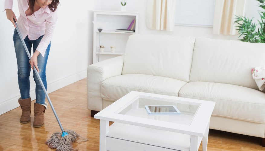 A woman mopping her living room floor. A woman mopping her living room floor.