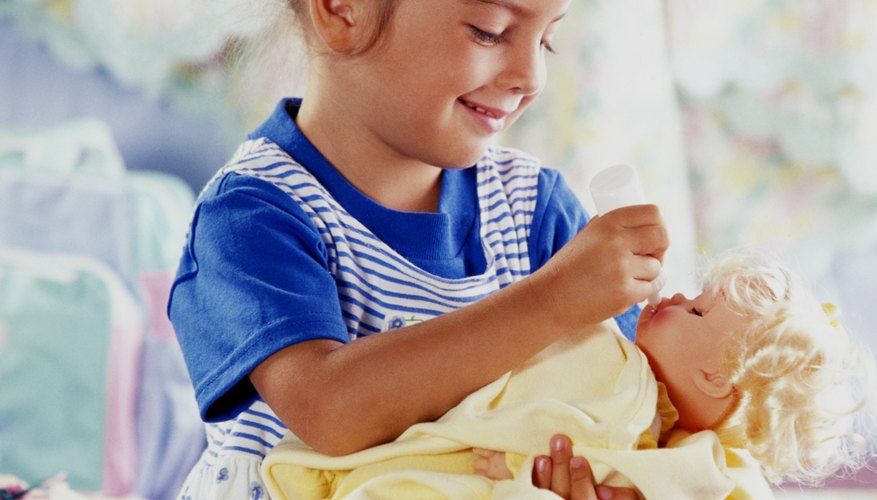 Young girls enjoy different types of dolls. Young girls enjoy different types of dolls.