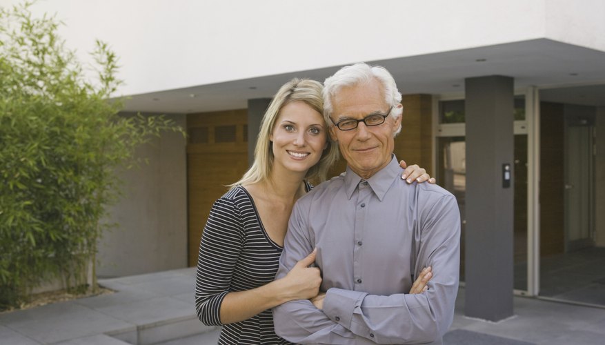 A father and daughter standing in the driveway in front of a home. A father and daughter standing in the driveway in front of a home.