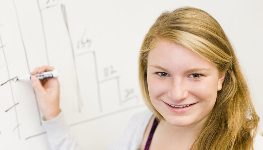 Young student drawing graph on whiteboard. Young student drawing graph on whiteboard.