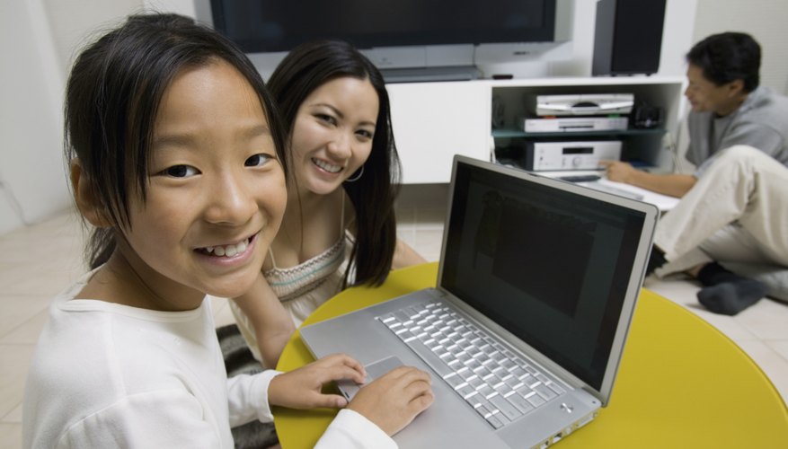 A mother, father, and daughter connect a laptop to their home theater system A mother, father, and daughter connect a laptop to their home theater system