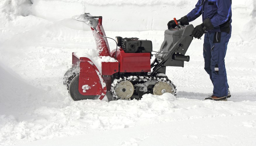 A man using a dual-stage snowblower A man using a dual-stage snowblower
