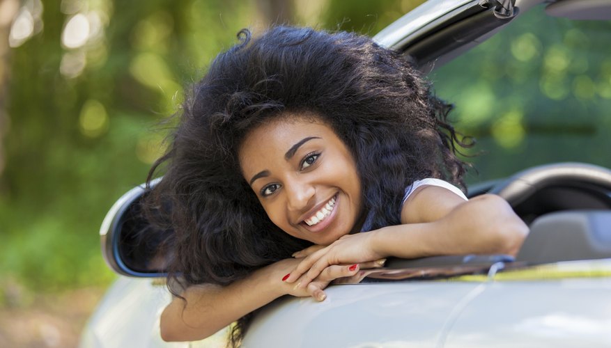 A teenage girl sitting in the driver's seat of a convertible. A teenage girl sitting in the driver's seat of a convertible.