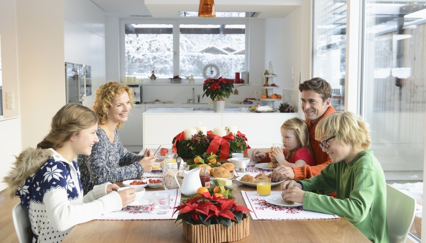 Smiling young family sitting around a breakfast table. Smiling young family sitting around a breakfast table.