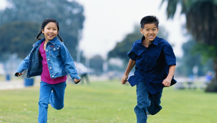Two children running while playing outside. Two children running while playing outside.