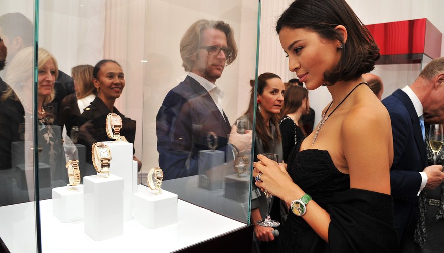 Young woman admires Cartier watches in display case Young woman admires Cartier watches in display case