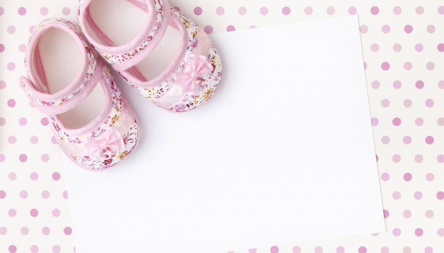An overhead view of pink baby booties on top of an envelope. An overhead view of pink baby booties on top of an envelope.