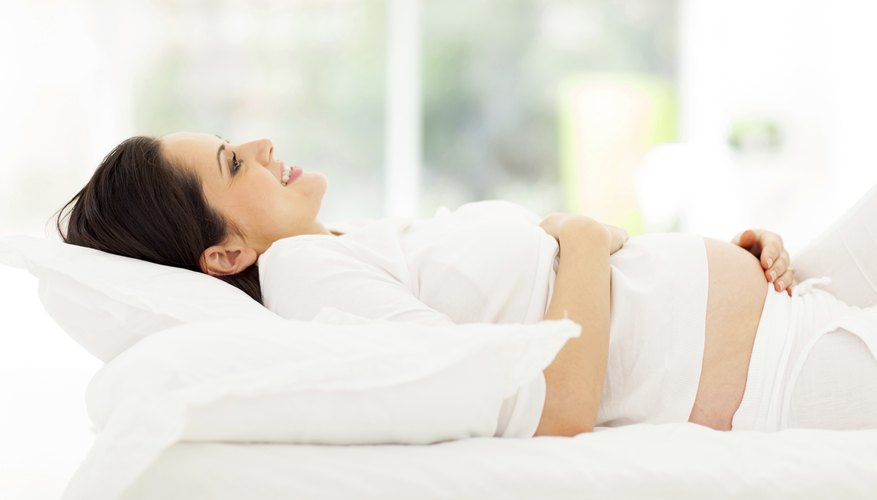 Pregnant woman laying on bed. Pregnant woman laying on bed.