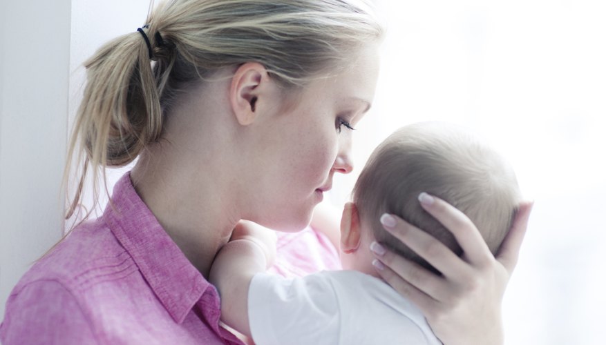 Mother supporting baby's head while holding child. Mother supporting baby's head while holding child.