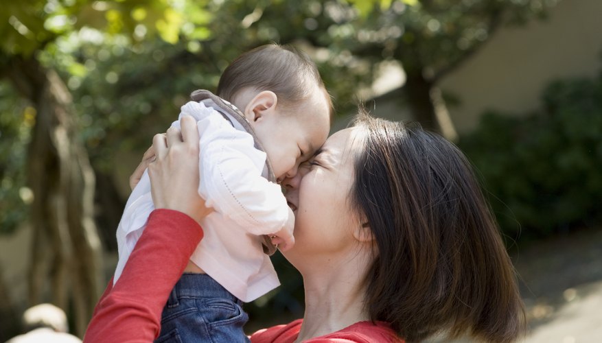A happy woman holding an infant face to face. A happy woman holding an infant face to face.