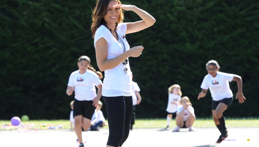 A woman teaching students a physical fitness game. A woman teaching students a physical fitness game.