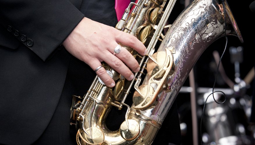 A close-up of a man playing the saxophone on a stage. A close-up of a man playing the saxophone on a stage.