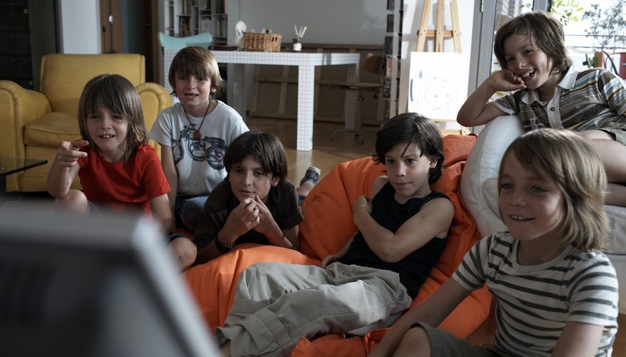 Young boys are watching the television. Young boys are watching the television.