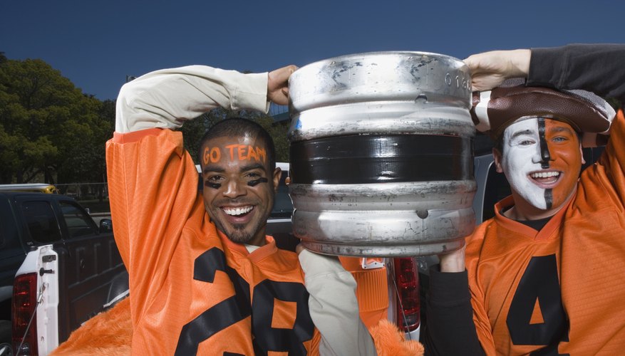Men carrying a beer keg at football game Men carrying a beer keg at football game