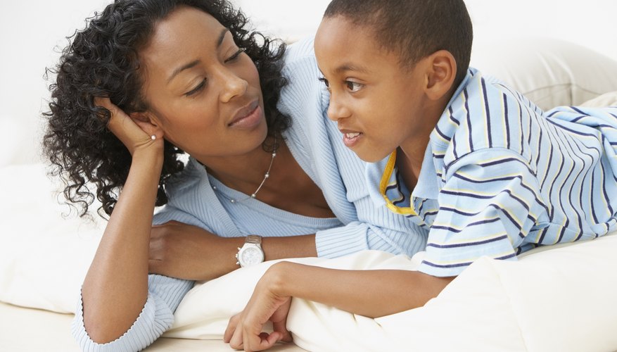 Mother looking at her son while laying on living room floor. Mother looking at her son while laying on living room floor.