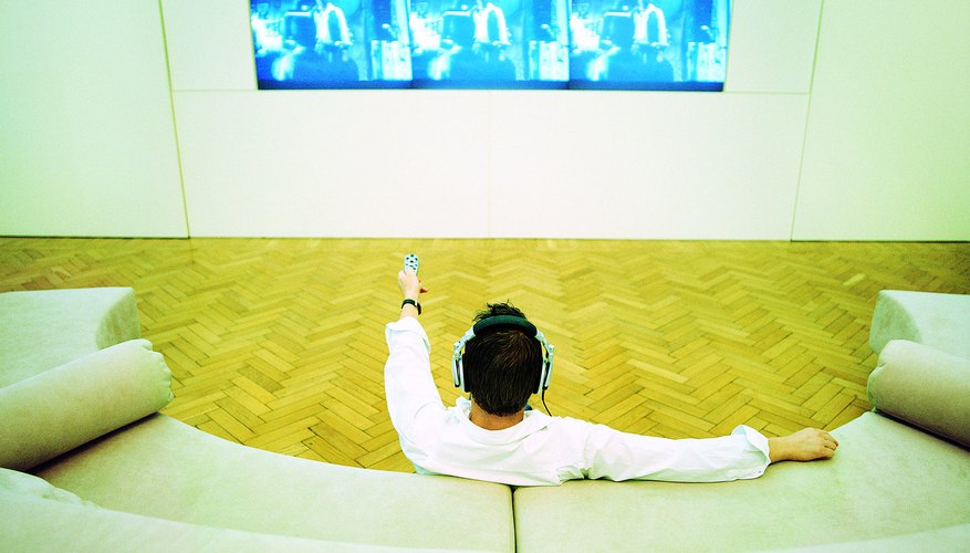 Photo Credit: Digital Vision./Digital Vision/Getty Images Man relaxing at home watching a plasma screen