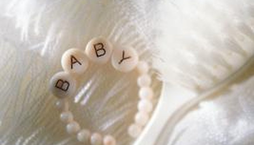 Top a baby blanket cake with small gift items. Top a baby blanket cake with small gift items.