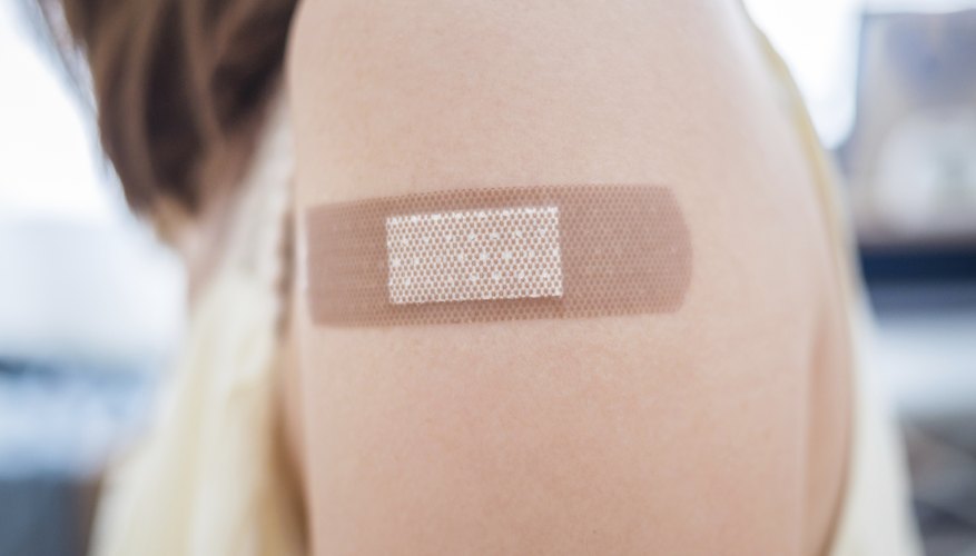 A bandage covers the skin on a woman's arm. A bandage covers the skin on a woman's arm.