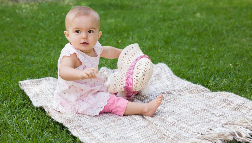 One year old baby on blanket at park One year old baby on blanket at park