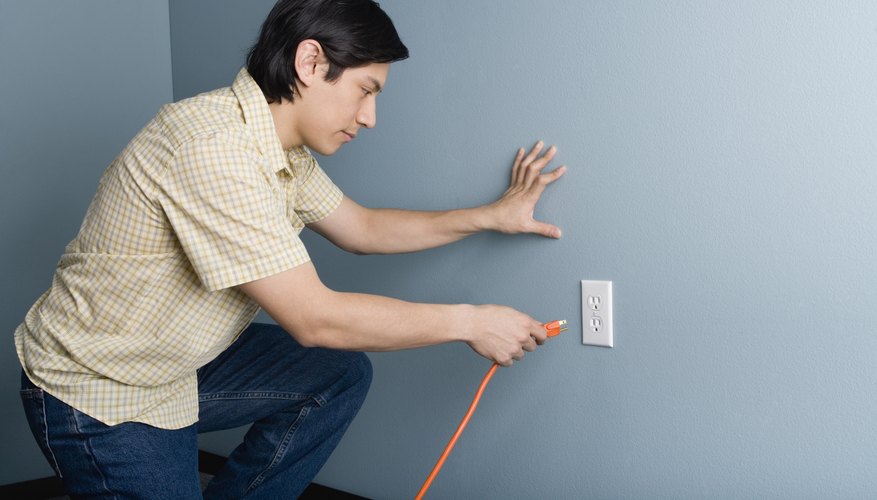 Man plugging a cord into an outlet Man plugging a cord into an outlet