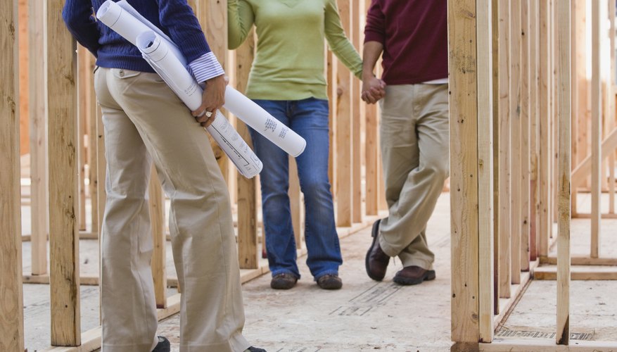 People are walking through a house being built. People are walking through a house being built.