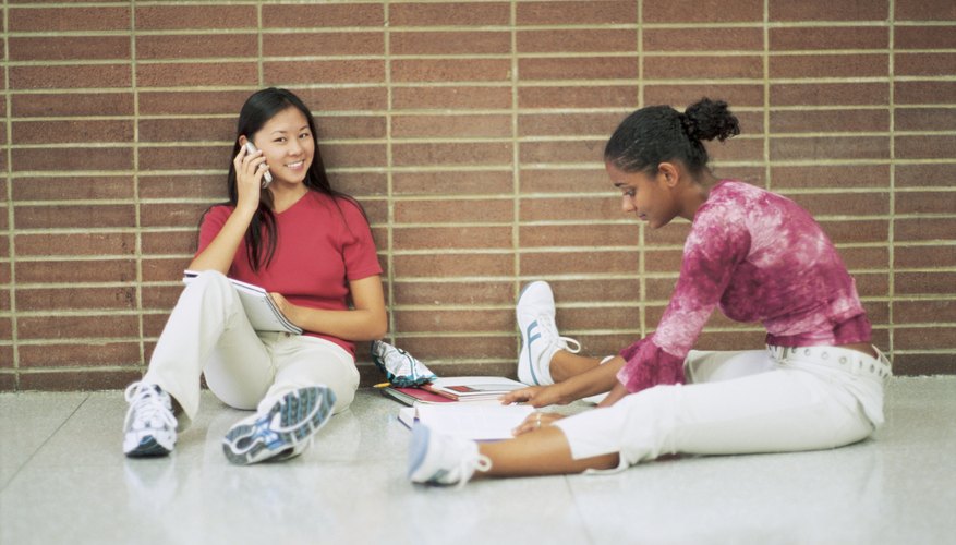 Student talking on cellphone in school hallway. Student talking on cellphone in school hallway.