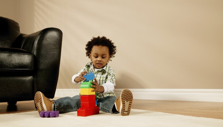 Three year old playing with blocks in living room. Three year old playing with blocks in living room.