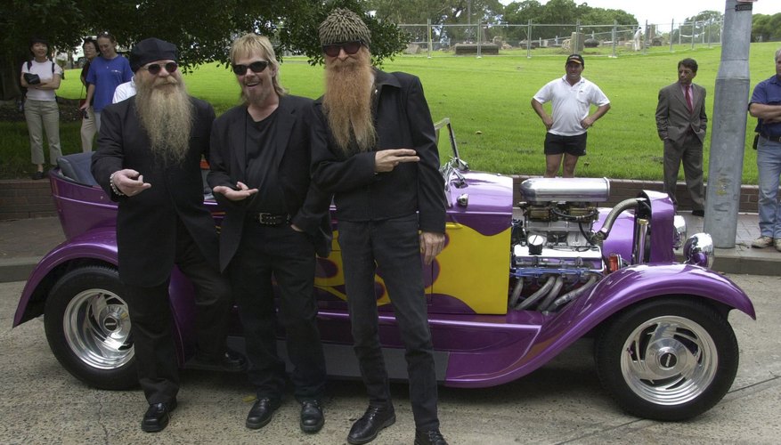 Rock band ZZ Top pose in front of hot rod Rock band ZZ Top pose in front of hot rod
