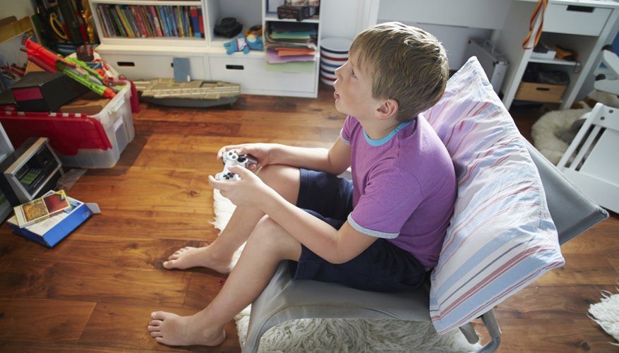 Boy holding a remote control joystick for a PlayStation. Boy holding a remote control joystick for a PlayStation.